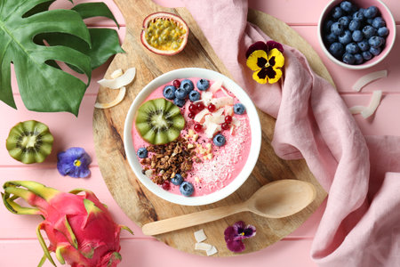 Flat lay composition with tasty smoothie bowl on pink wooden tableの写真素材