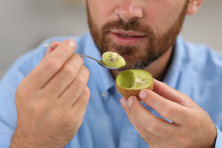Man eating fresh kiwi with spoon, closeupの写真素材