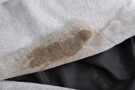 Gray jacket with stain of coffee, closeup