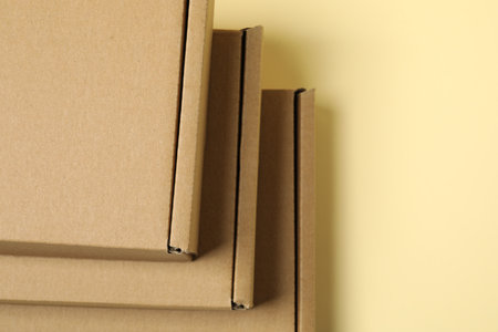 Many closed cardboard boxes on pale yellow background, above view. Space for textの写真素材