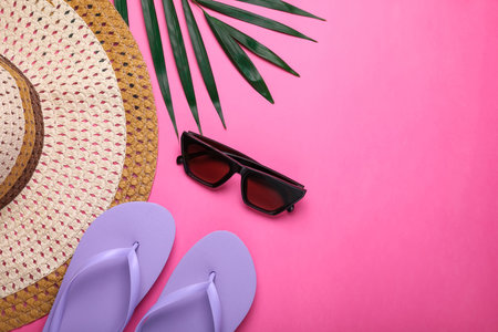 Flat lay composition with beach accessories on pink background. Space for textの写真素材