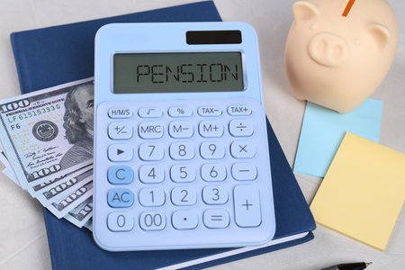 Calculator, dollar banknotes, piggy bank, notebook and sticky notes on light gray table. Retirement conceptの写真素材