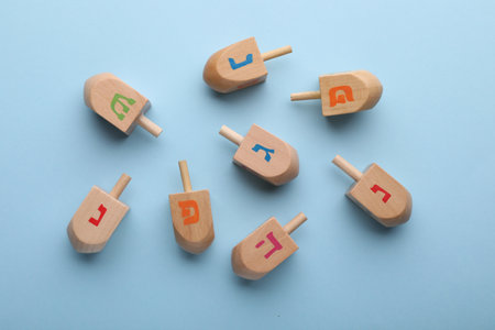 Wooden dreidels on light blue background, flat lay. Traditional Hanukkah gameの写真素材