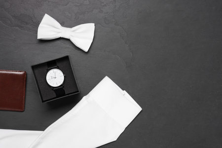 Stylish white bow tie, wrist watch, wallet and shirt on gray background, flat lay. Space for textの写真素材