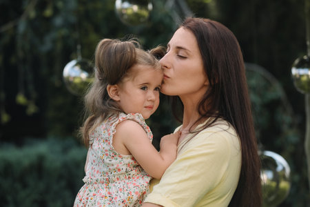 Portrait of mother with her cute daughter in parkの写真素材