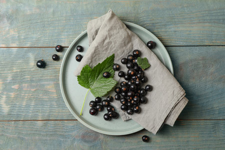 Ripe blackcurrants and leaves on wooden rustic table, flat layの写真素材