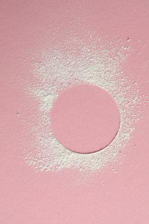 Frame made of rice loose face powder on pink background, top view. Space for textの写真素材