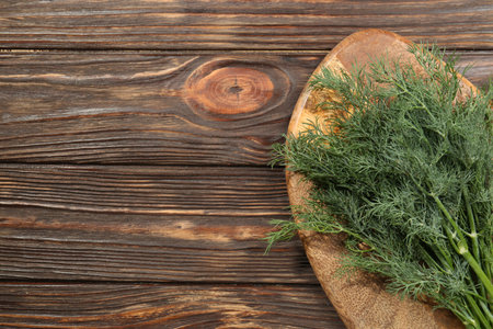 Bunch of fresh green dill on wooden table, top view. Space for textの写真素材
