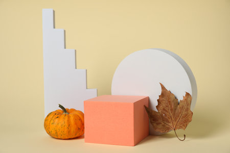 Autumn presentation for product. Geometric figures, pumpkin and dry leaf on beige backgroundの写真素材