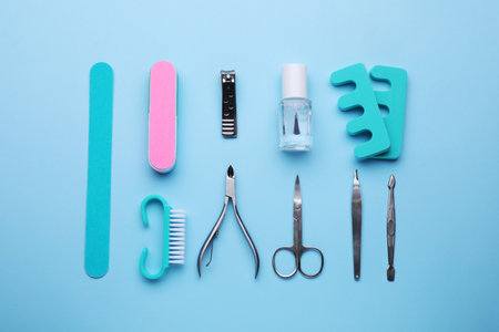 Set of pedicure tools on light blue background, flat layの写真素材