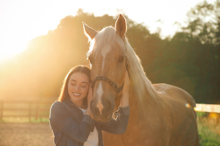 Beautiful woman with adorable horse outdoors on sunny day. Lovely domesticated petの写真素材