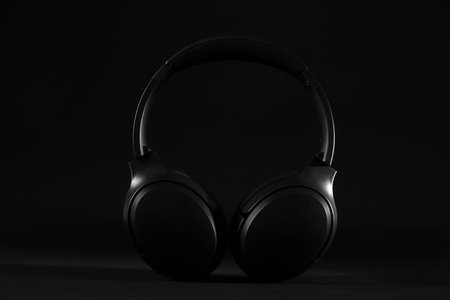 Stylish modern wireless headphones on black backgroundの写真素材