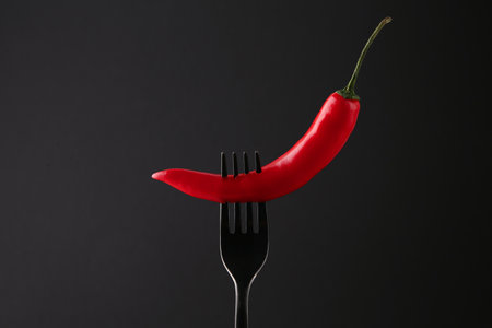 Fork with chili pepper on black backgroundの写真素材