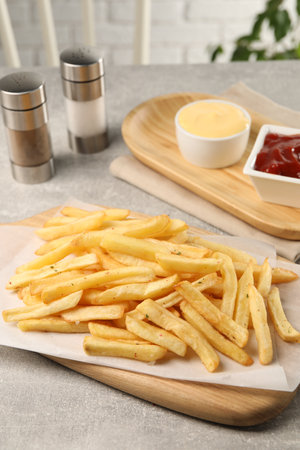 Delicious French fries served with sauces on light gray tableの写真素材