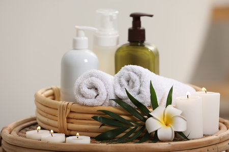 Spa products, burning candles, plumeria flower and tropical leaf on table, closeupの写真素材