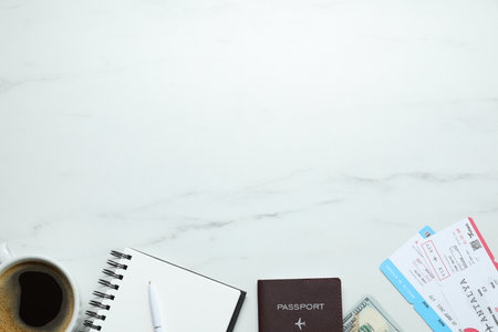 Flat lay composition with passport, notebook and tickets on white marble table, space for text. Business tripの写真素材