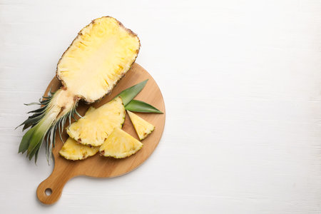 Ripe juicy pineapple on white wooden table, top view. Space for textの写真素材