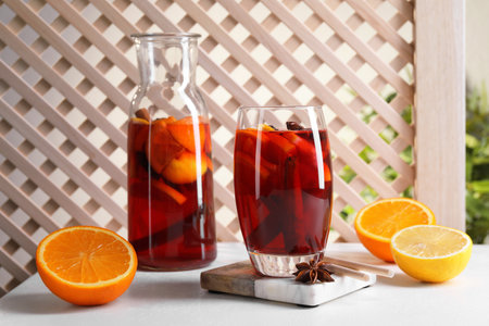 Aromatic punch drink and ingredients on white tableの写真素材