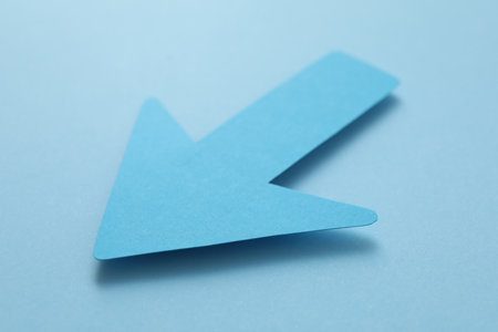 One paper arrow on light blue background, closeupの写真素材