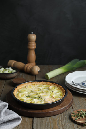 Tasty leek pie, fresh stalk and thyme on wooden tableの写真素材