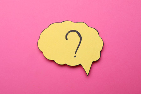 Paper speech bubble with question mark on pink background, top viewの写真素材