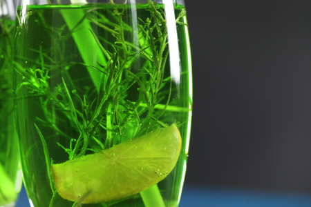 Glass of homemade refreshing tarragon drink with lemon slice, closeup