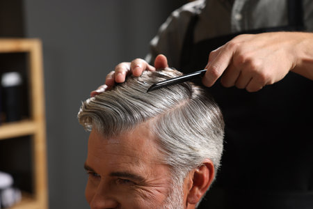 Hair styling. Professional hairdresser working with client in barbershop, closeupの写真素材