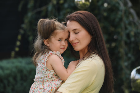 Portrait of mother with her cute daughter in parkの写真素材