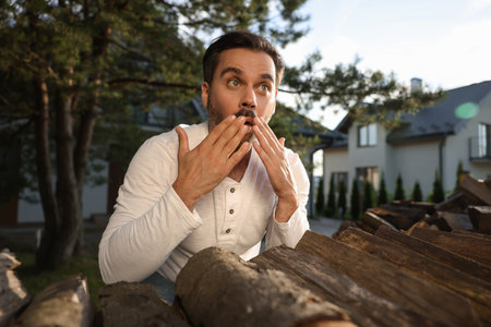 Concept of private life. Curious man spying on neighbours over firewood outdoorsの写真素材