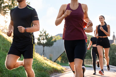 Group of people running outdoors on sunny dayの写真素材