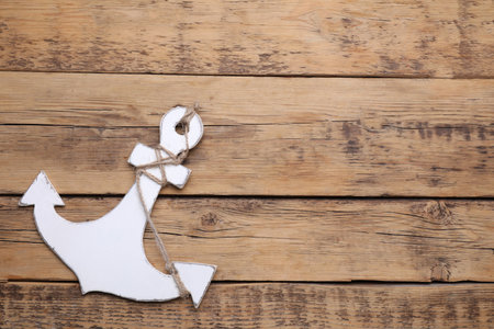 Anchor with hemp rope on wooden table, top view. Space for textの写真素材