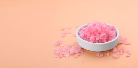 Bowl with aromatic sea salt on coral background, space for text. Banner designの写真素材