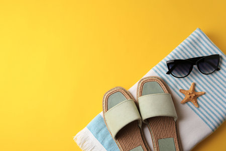 Flat lay composition with beach accessories on yellow background, space for textの写真素材