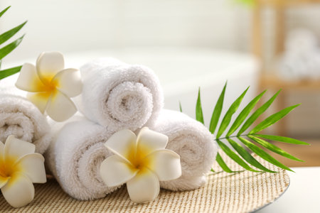 Spa composition. Towels, plumeria flowers and palm leaves on table indoors, closeupの写真素材