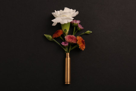 Bullet case with beautiful flowers on black background, top viewの写真素材