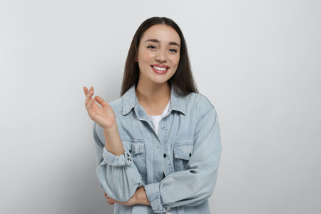 Portrait of happy young woman in jeans jacket on white backgroundの写真素材