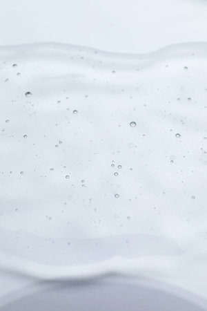 Sample of cosmetic oil on reflective surface, closeup