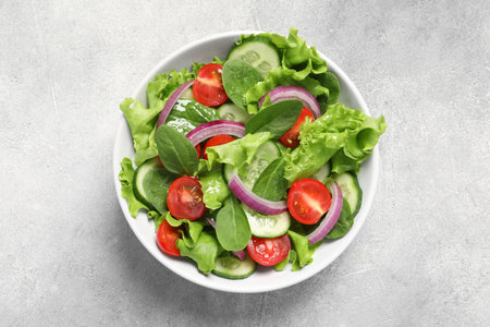 Delicious vegetable salad on light gray table, top viewの写真素材