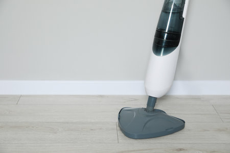 One modern steam mop on floor near gray wall, space for textの写真素材