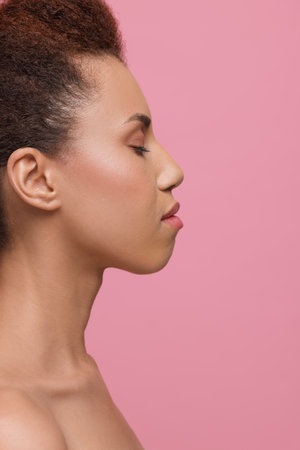 Beautiful young woman with glamorous makeup on pink backgroundの写真素材