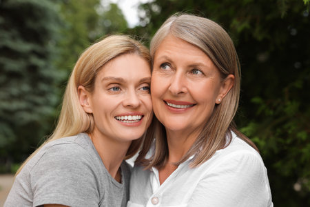 Happy mature mother and her daughter outdoors