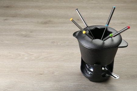 Fondue set on wooden table, space for textの写真素材