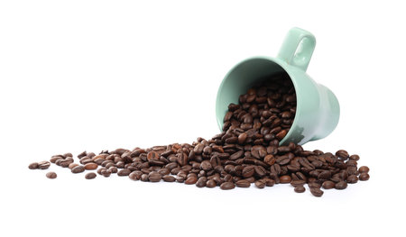 Coffee beans and overturned cup isolated on whiteの写真素材