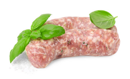 Raw homemade sausages and basil leaves isolated on whiteの写真素材