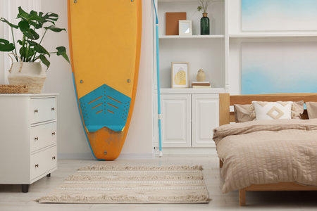 SUP board, bed and furniture in room. Interior designの写真素材