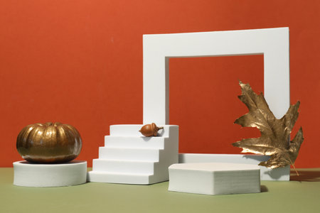 Autumn presentation for product. Geometric figures, golden leaf, pumpkin and acorn on color...