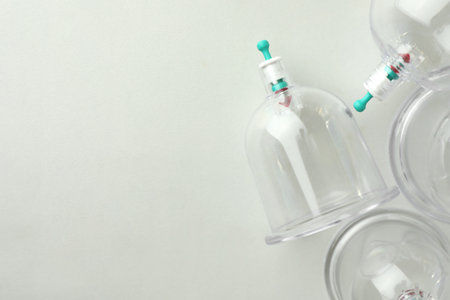 Plastic cups on white table, flat lay with space for text. Cupping therapyの写真素材
