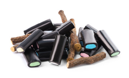 Many tasty candies and dried sticks of liquorice root isolated on whiteの写真素材