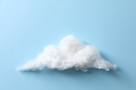 Cloud made of cotton on light blue backgroundの写真素材