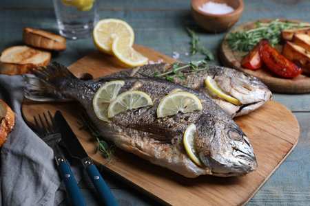 Delicious baked fish served on wooden rustic table, closeup. Seafoodの写真素材